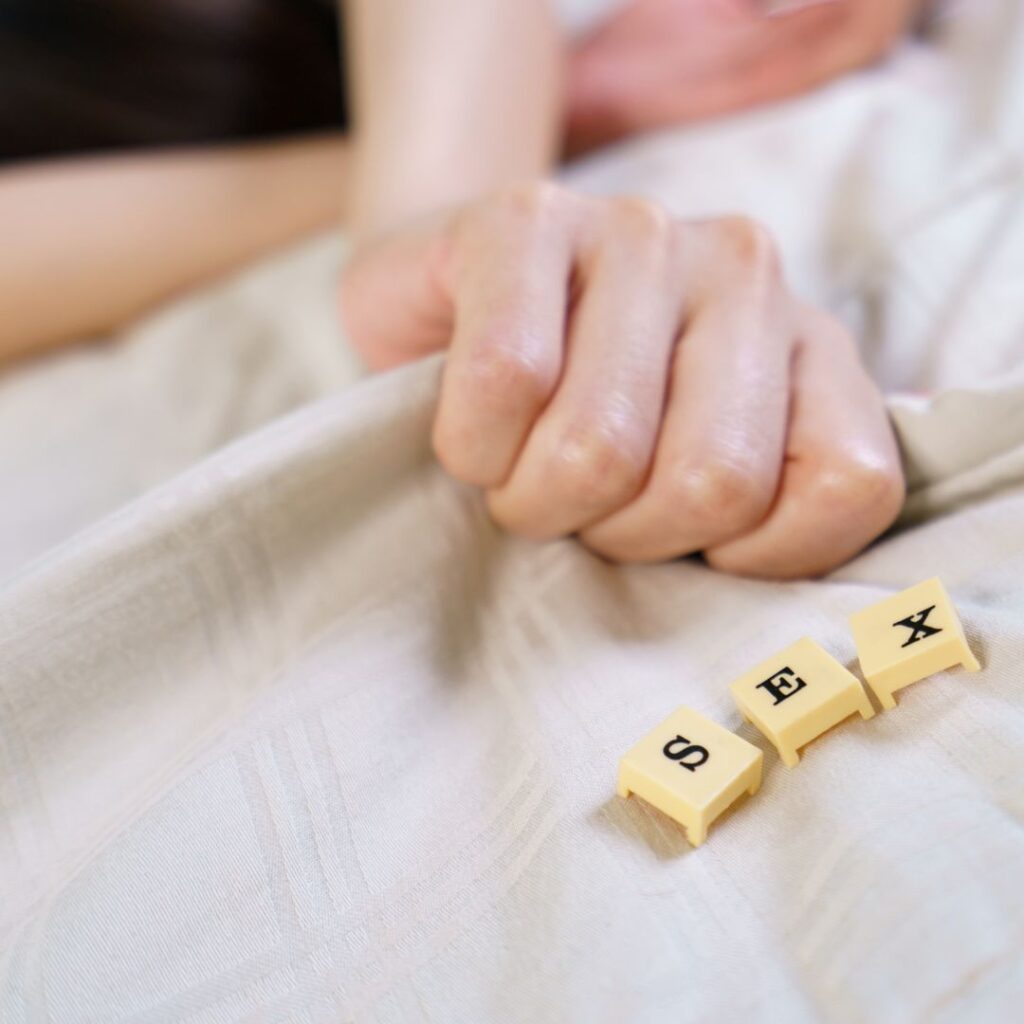 זוג במיטה עם המילה סקס