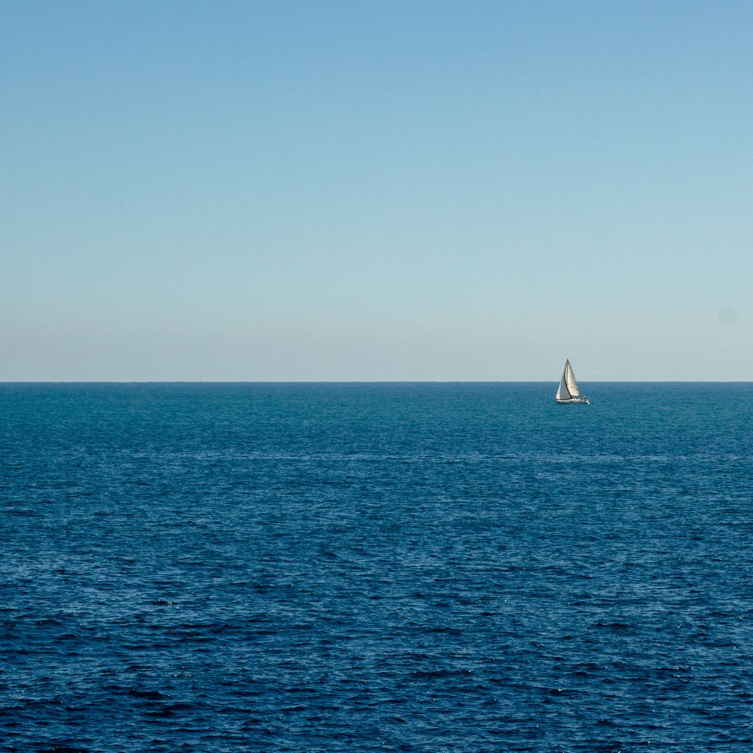 ים עם סירה ומפרש לבן